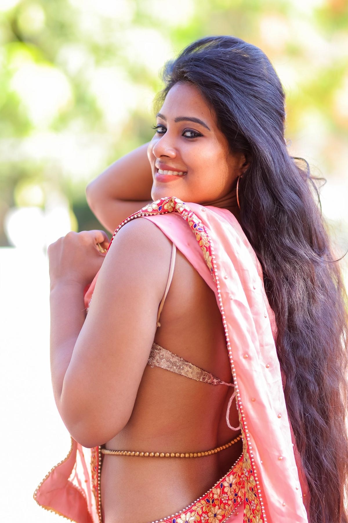 Divya is seen wearing a pink low hips saree wrapped casually on a thin slee...